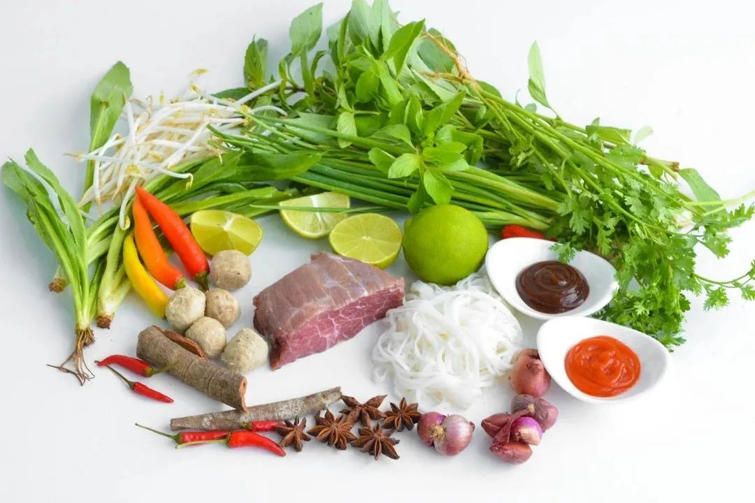 Chili sauce and condiments for pho enhancing the dish's flavors.
