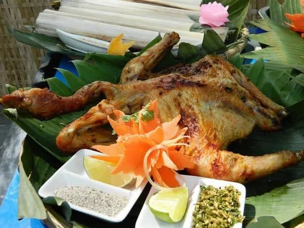 Enjoy Bản Đôn grilled chicken by the flickering fire, with can wine and bamboo rice