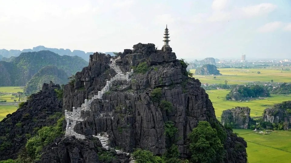 Tourists hiking Ngoa Long Mountain to admire the panoramic view of Tam Coc from above