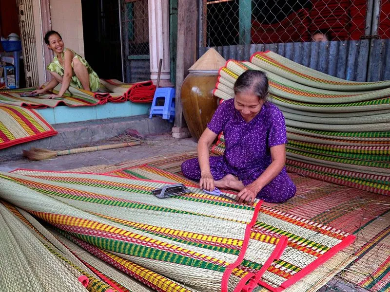 Local artisan weaving traditional mats by hand