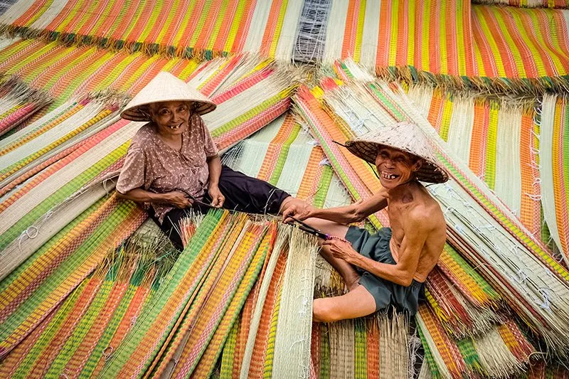 Smiling baker making Banh Dap, a local specialty