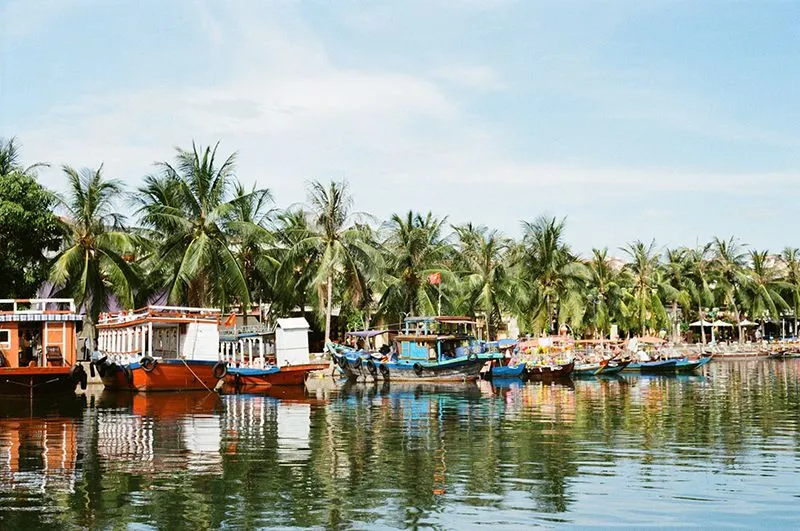 Thung boats docked along a riverbank in Hoi An