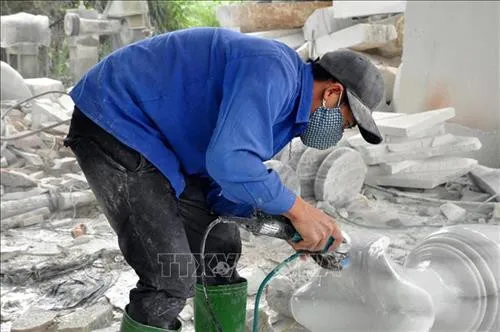 Craftsmen meticulously grind and polish white stone vases.