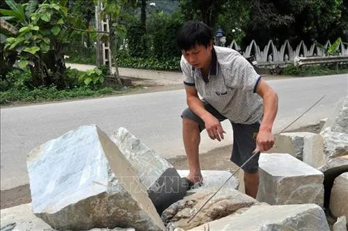 Để tạo ra tác phẩm đẹp nghệ nhân phải tỉ mỉ từ khâu chọn đá thô. Ảnh: Việt Dũng - TTXVN