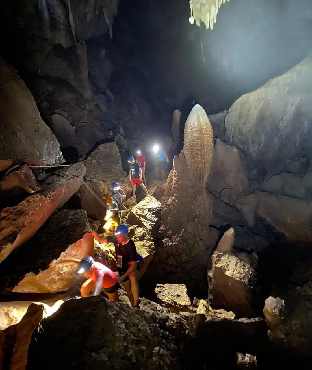 Visitors trekking on a stalactite-covered path