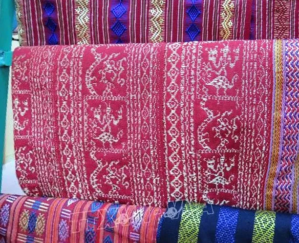 Close-up of intricate and colorful patterns on a piece of Cham brocade fabric, highlighting cultural symbols.