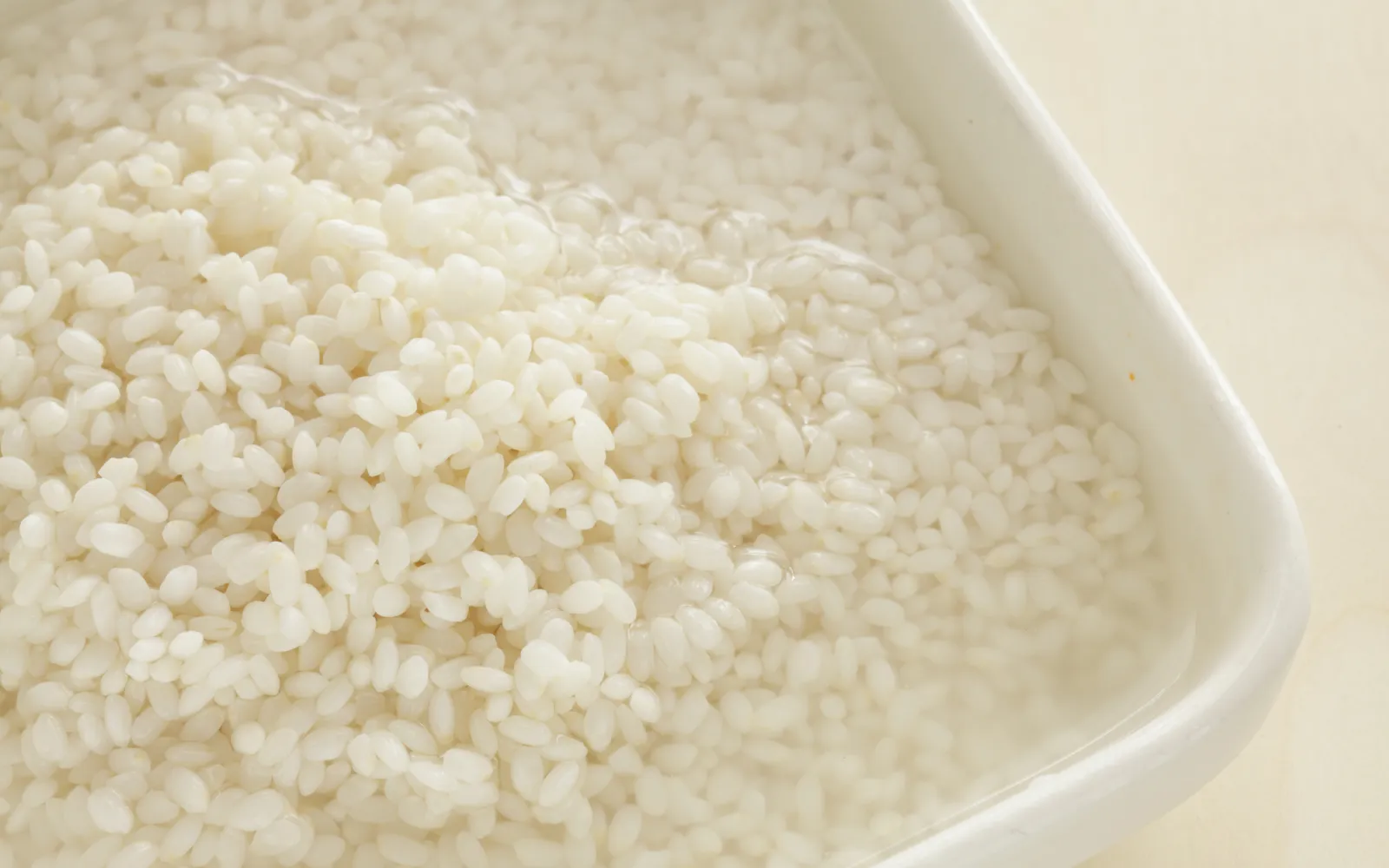 Glutinous rice soaking in ash water, a crucial step in creating the color and flavor of ash dumplings.
