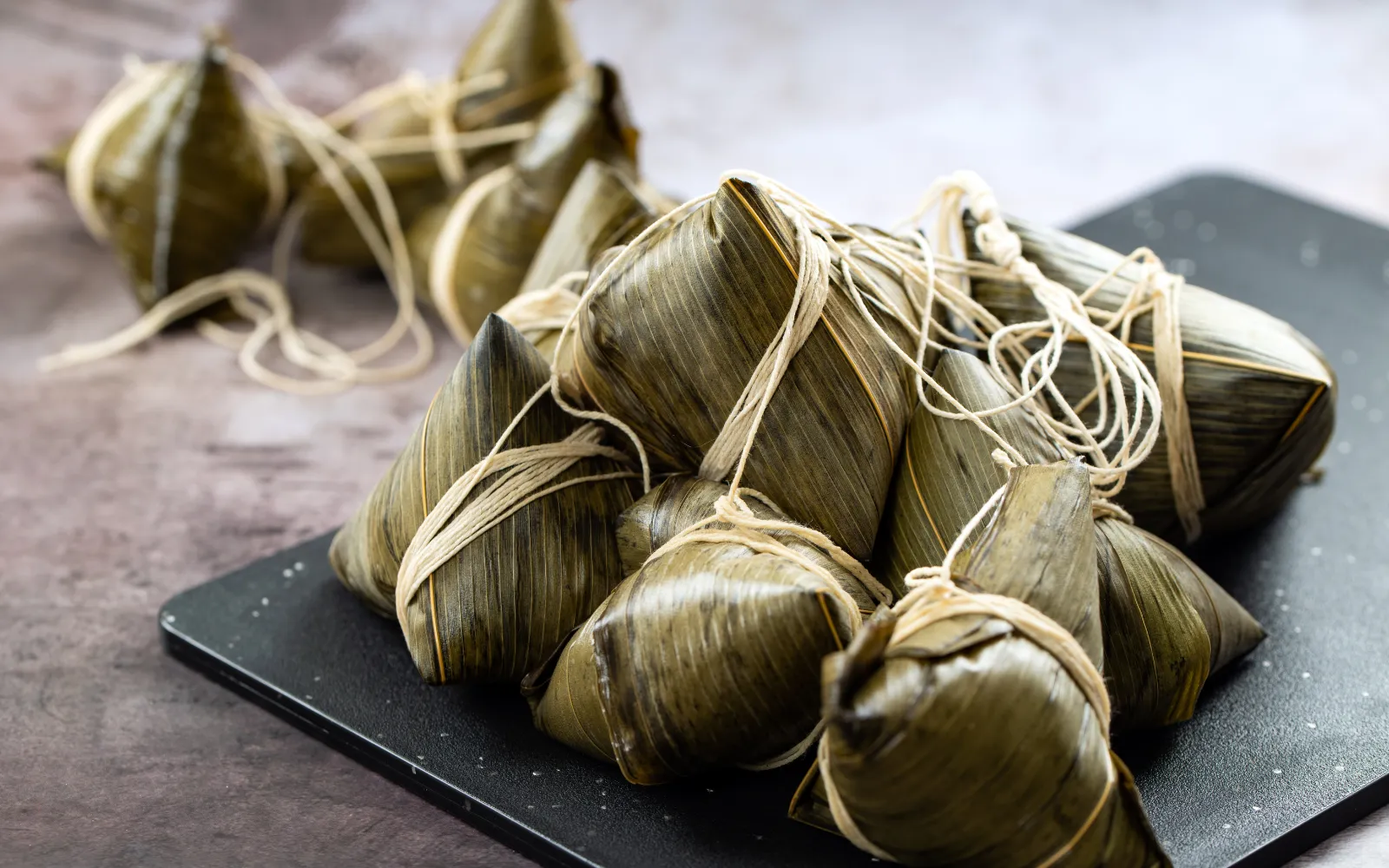 Ash dumplings dipped in molasses, a refreshing and cooling dish loved during Tết Đoan Ngọ.
