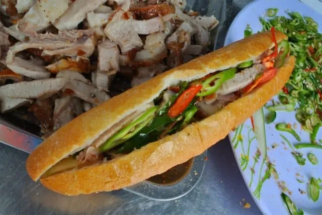 Taking a bite of crispy banh mi with flavorful roasted pork filling is the best