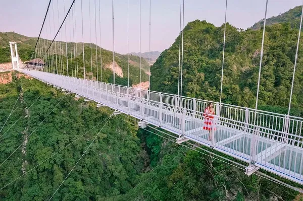 People walking across Bach Long Glass Bridge in Moc Chau
