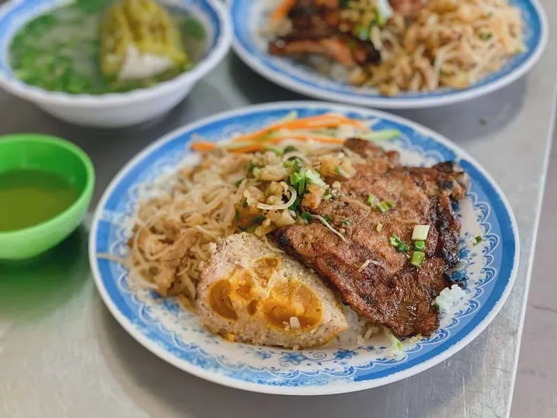 Cơm Tấm Ba Há in Saigon, known for its unique salted egg meatloaf, with a plate featuring broken rice and the signature dish.
