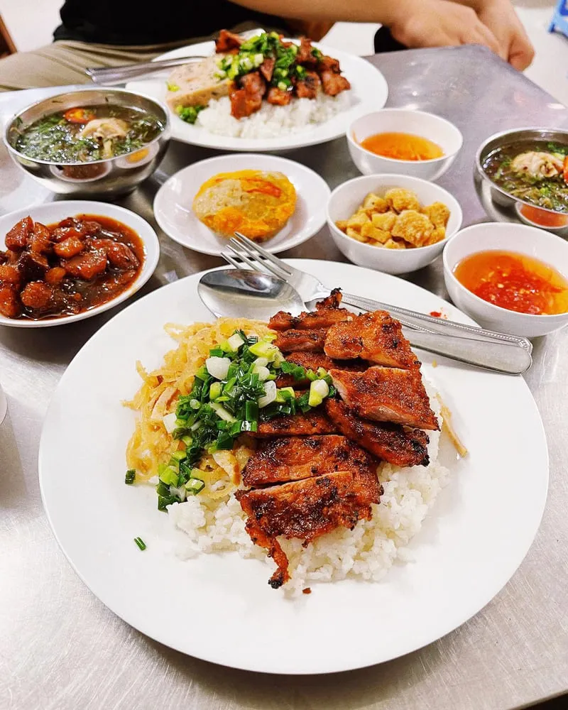 A simple and affordable plate of Cơm Tấm Bà Mười in Saigon, showcasing budget-friendly broken rice with pork chop and side dishes.