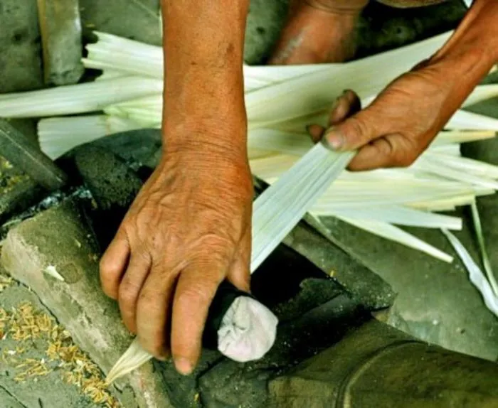 Công đoạn chuốt lá nón tại làng Phú Cam.