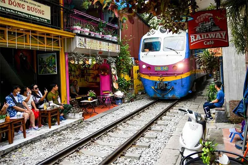 Đoàn tàu chậm rãi trên đường tàu Phùng Hưng, hòa mình vào nhịp sống sôi động của Hà Nội.