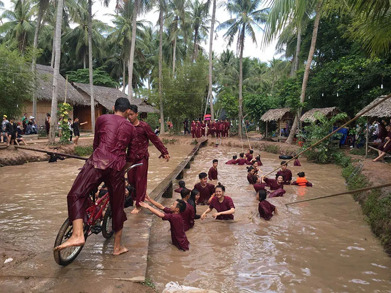 Tourists excitedly participate in the wobbly bridge game at Lang Be tourist area.