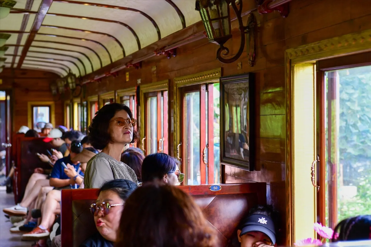 Tourists admiring the scenery of Da Lat from inside the train carriage