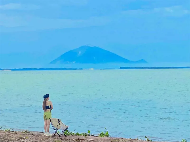 Visitors strolling and admiring Ba Den Mountain from Dau Tieng Lake