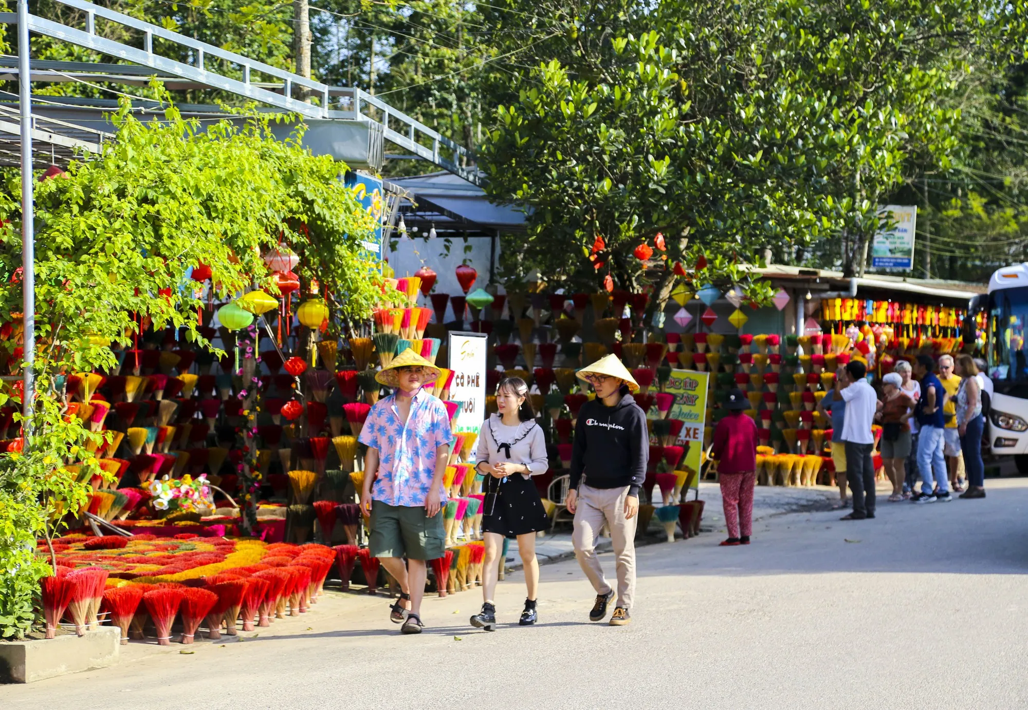 Tourists happily taking photos with colorful incense bundles at Thuy Xuan village.