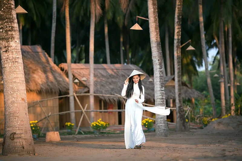 Tourists enjoy taking souvenir photos in Ba Ba traditional clothing at Lang Be tourist area.