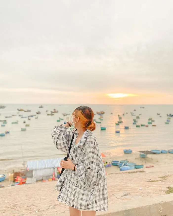 Tourists happily taking photos in Mui Ne fishing village, capturing memories of their coastal exploration trip.