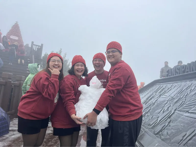 Tourists excitedly playing in the snow on Fansipan peak