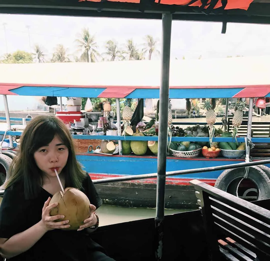 Tourists enjoying morning coffee on a boat at Cai Be Floating Market
