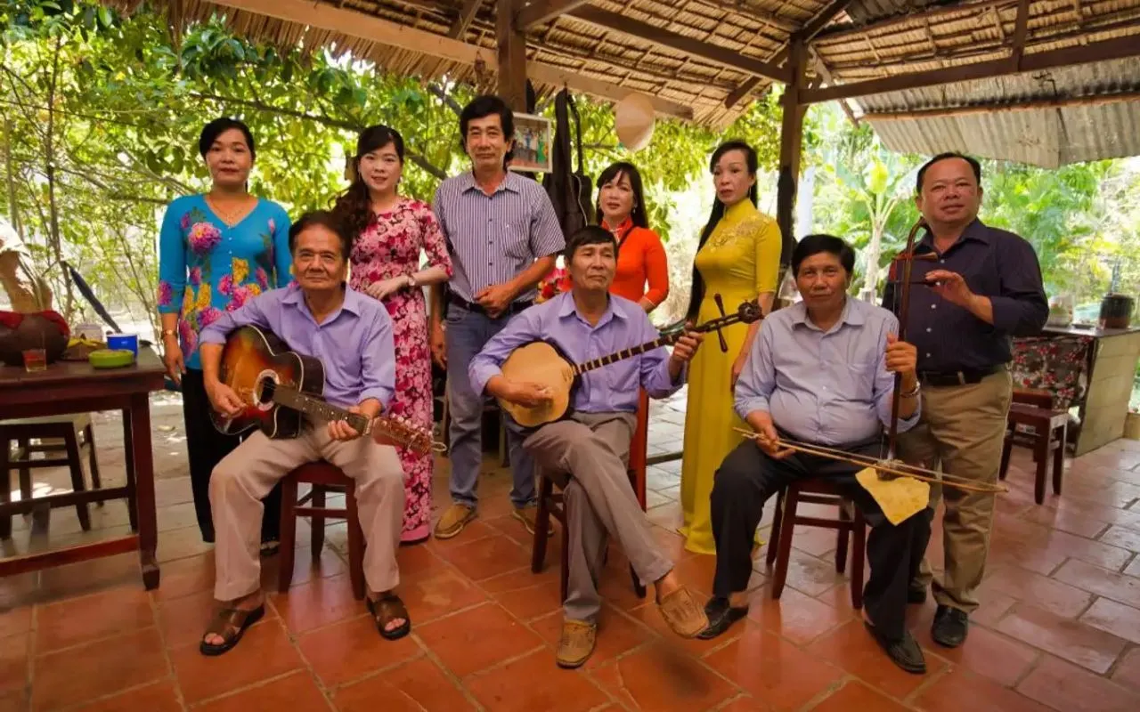 Tourists enjoying Đờn ca tài tử music and Mekong Delta fruits at Con Phung Island