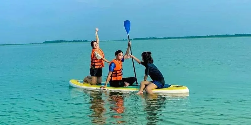 Visitors happily SUP paddling with friends on Dau Tieng Lake