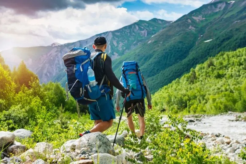 A cartoon style avatar of a hiker with a backpack and trekking poles