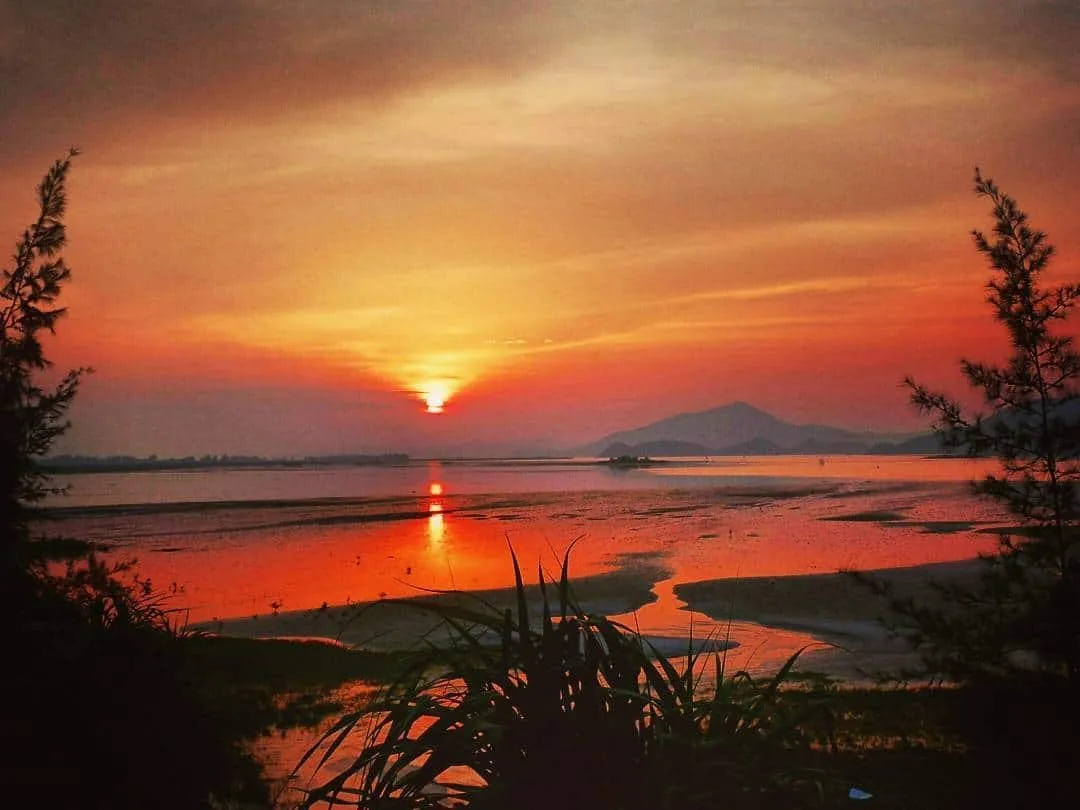 Sunset on Quan Lan Island with warm colors spreading across the sky and vast sea.