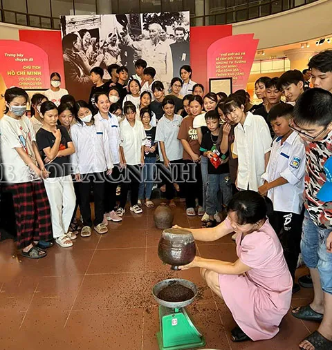 Students excited about the "Saving Rice Jar" activity within the thematic exhibition about President Ho Chi Minh at the provincial museum.
