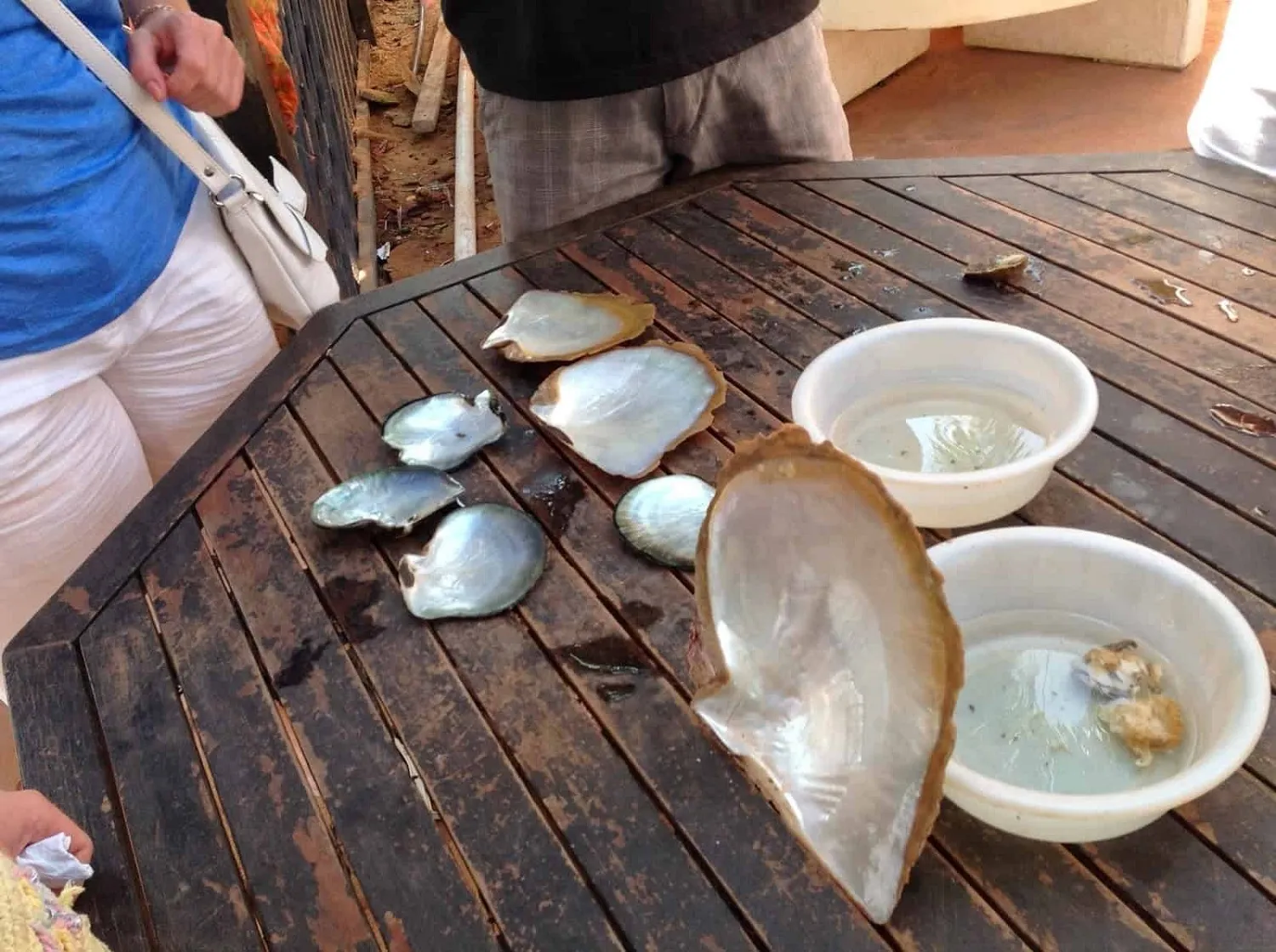 Customer receiving advice on distinguishing real from fake pearls.