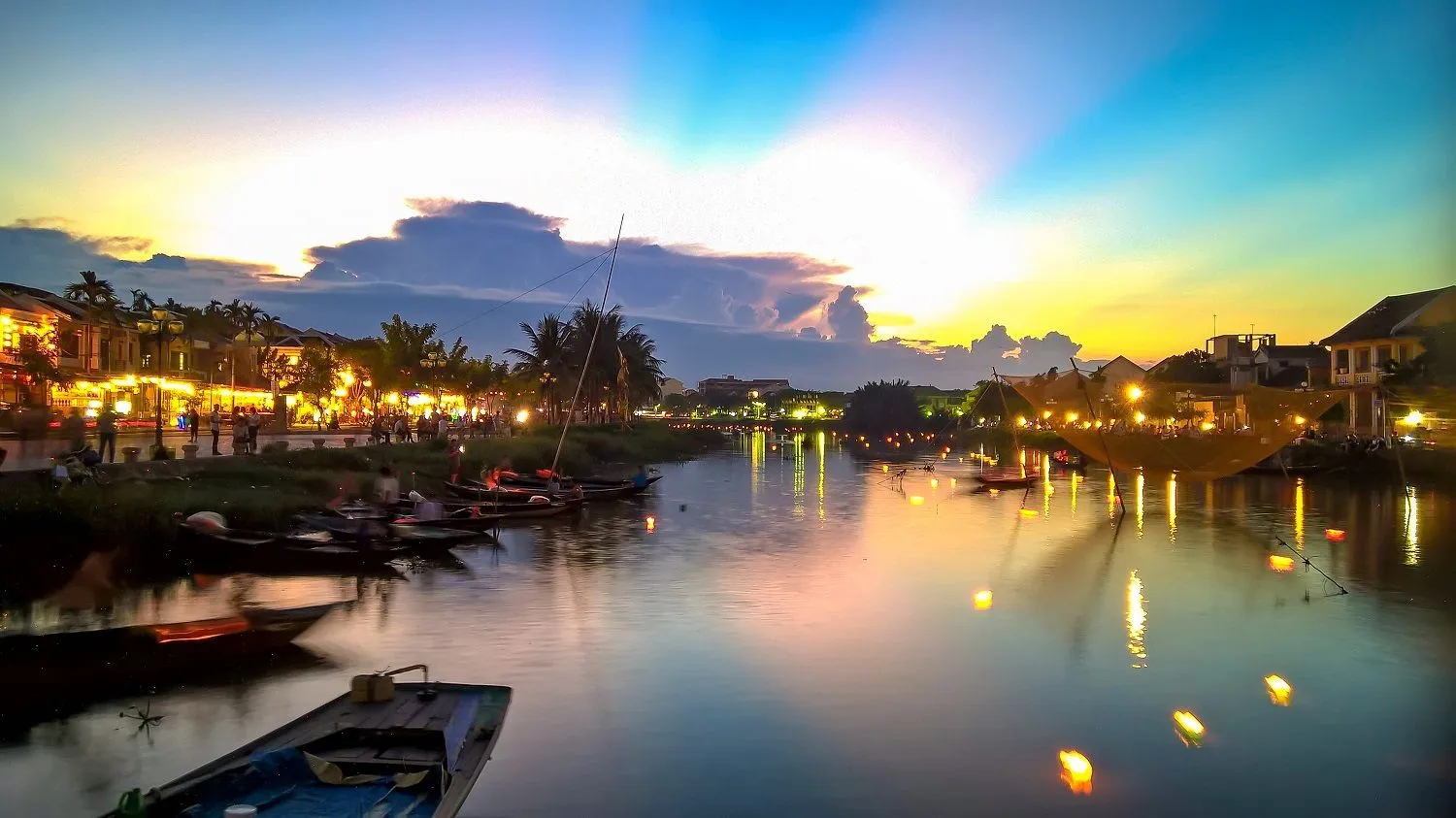 Riverside houses in Hoi An lit up at dusk, adding to the magical atmosphere.