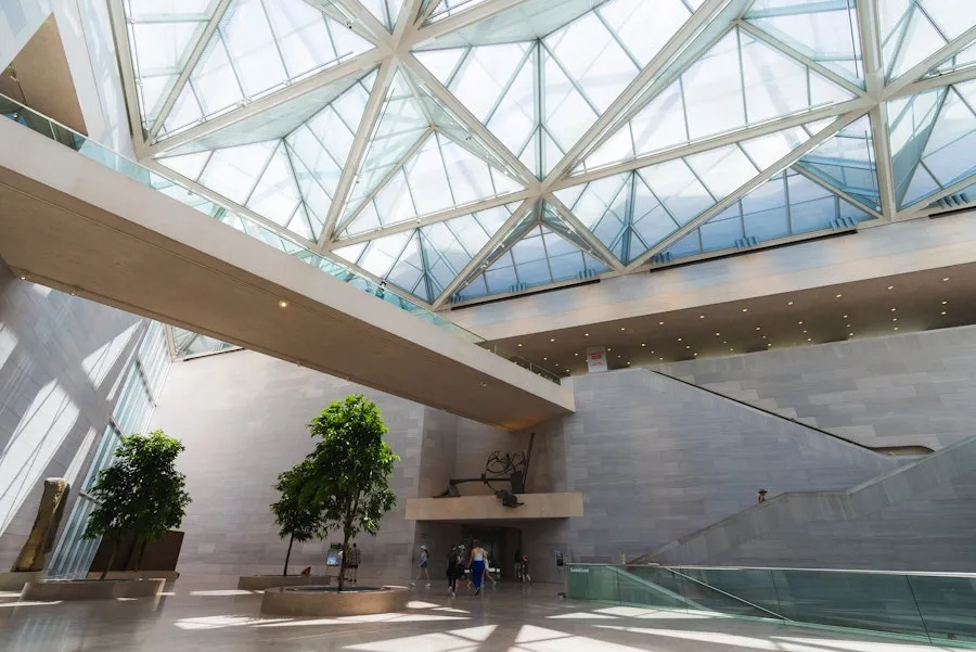 Interior view of the modern museum lobby with glass ceilings, open space, and minimalist design, where visitors explore and admire the unique architecture.