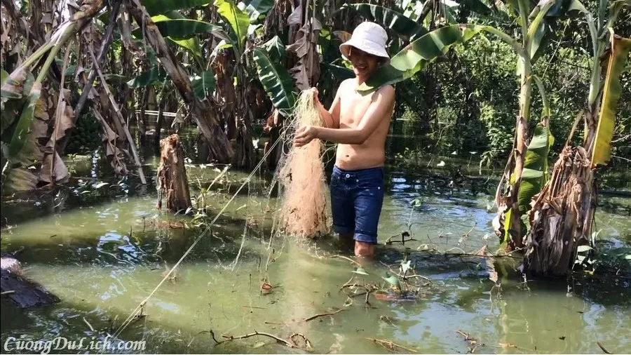 A table full of Mekong Delta flood season dishes, including fish soup and vegetables