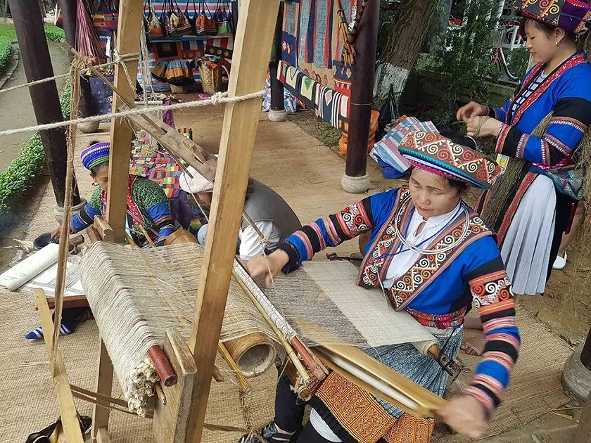 Mong woman diligently working at a traditional linen weaving loom