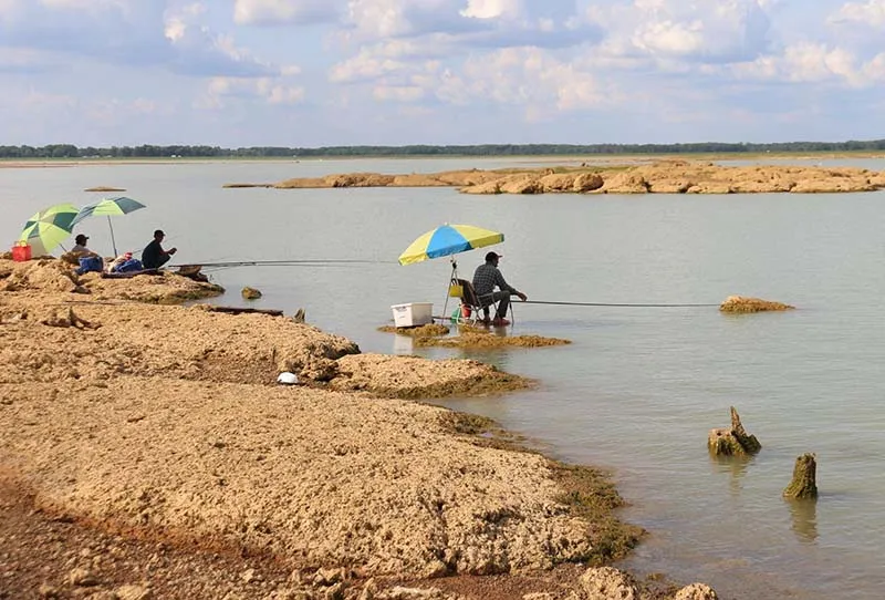 Many locals and tourists fishing together on Dau Tieng Lake