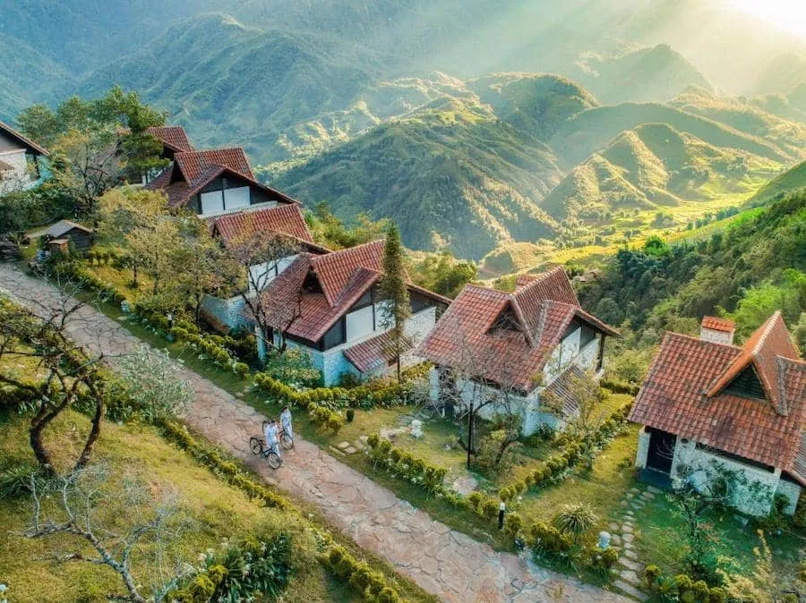 Red-roofed bungalows stand out amidst the Sapa mountains, offering a blend of traditional and modern beauty.