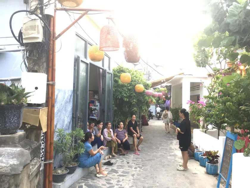 Women in a Vietnamese fishing village sharing stories while waiting for fishermen to return from the sea.