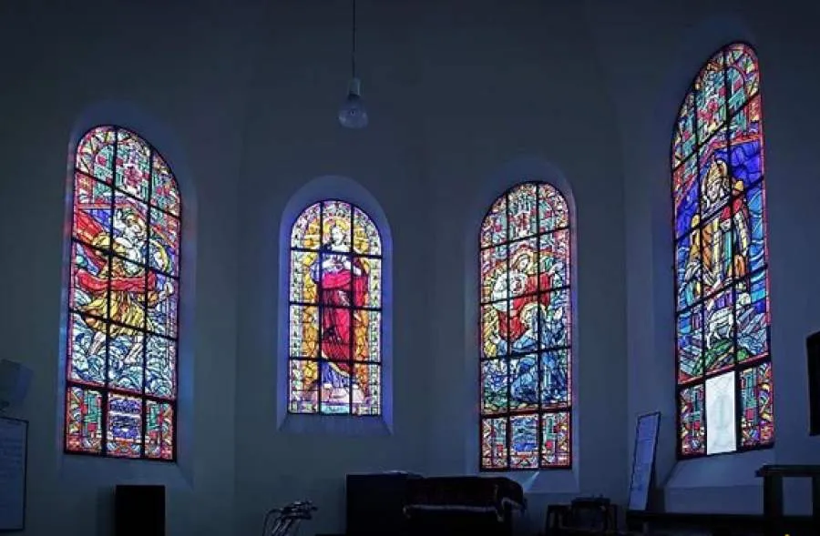 Colorful stained glass windows creating a magical atmosphere inside Da Lat Chicken Church.