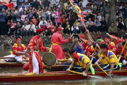 Conductor directs the rhythm for the boat racing team on the Nhuệ River