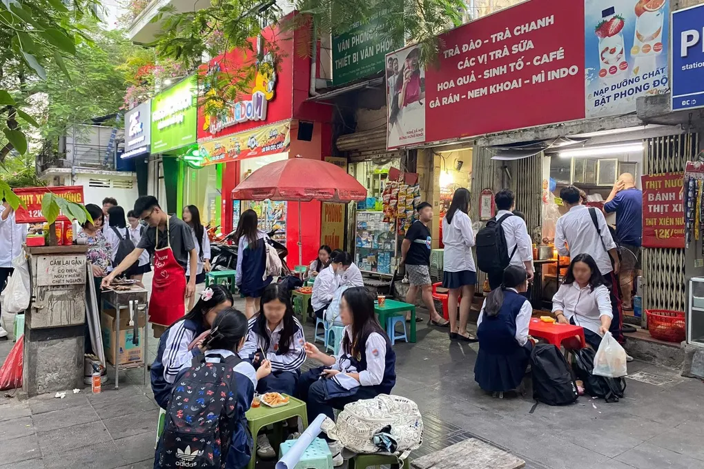 Crowded Hanoi student street food stall during rush hour.