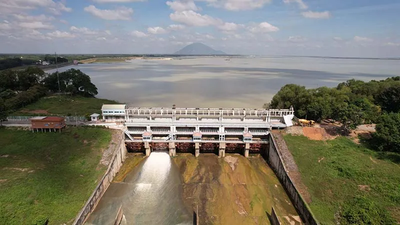 Lush green lawn and green trees covering both sides of the dam