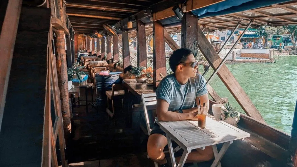 The Coffee Ship cafe, a boat-shaped cafe floating on the Saigon River, with outdoor seating visible.