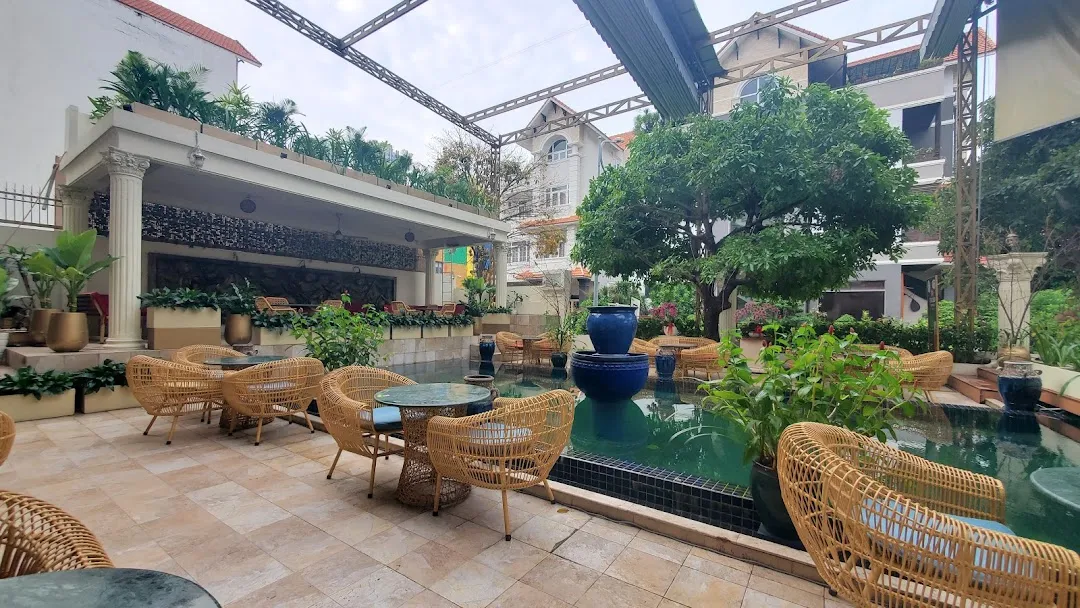 Outdoor seating area of The Kaphe Bistro, featuring modern design with a view of a lake and surrounding greenery.