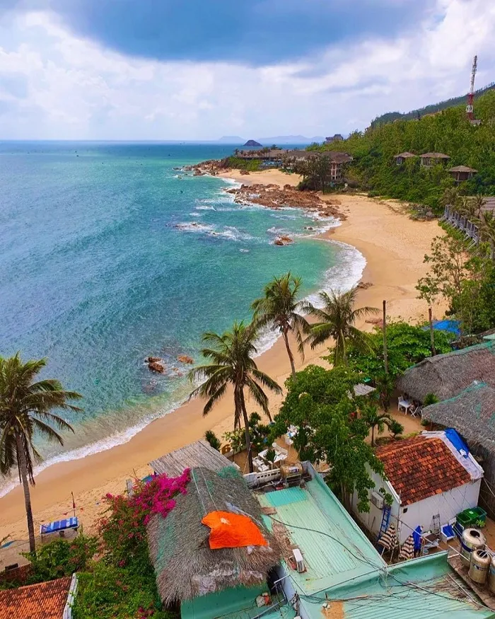 Panoramic view of Bai Xep fishing village from above, with houses close together and a charming curved coastline.