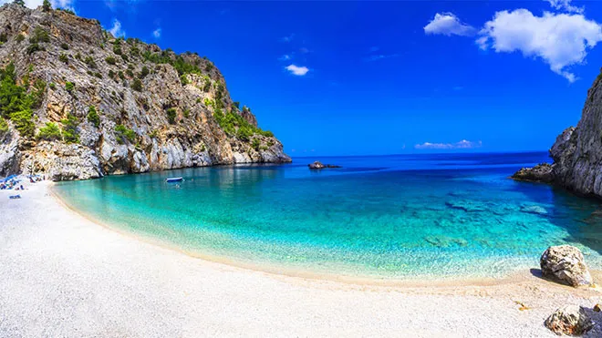 A stunning view of Apella beach in Karpathos with turquoise waters and pine trees