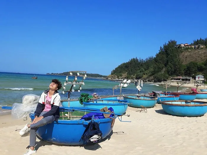 Wild beauty of Le Thuy fishing village with golden sand beach and peaceful anchored boats.